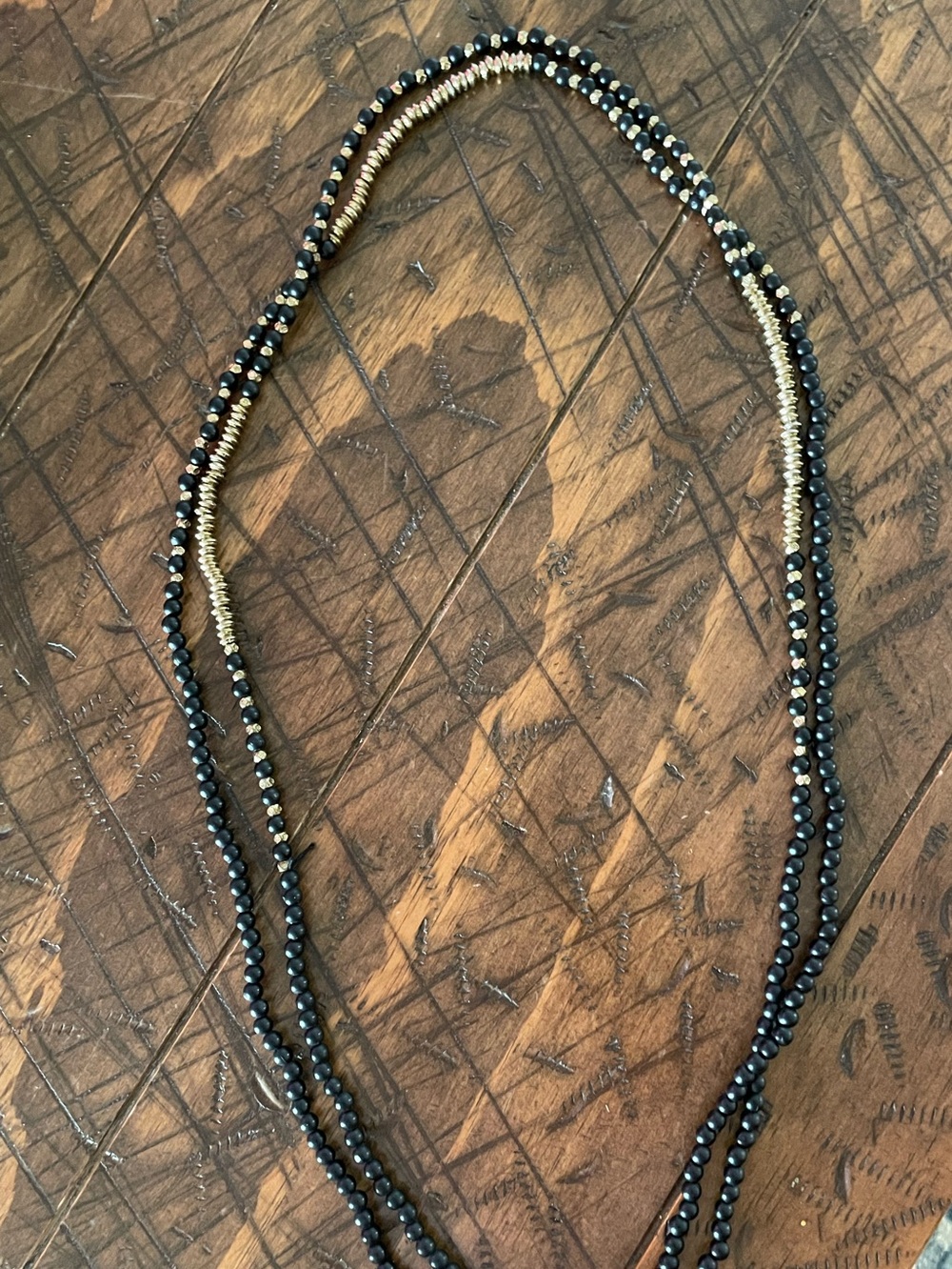 Single strand necklace featuring black and gold beads